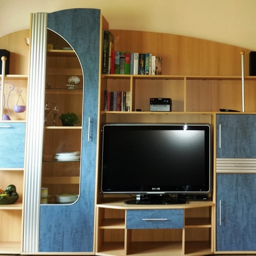 Wohnzimmer mit Schrankwand, Sat-TV und gemütliche Couchecke - 