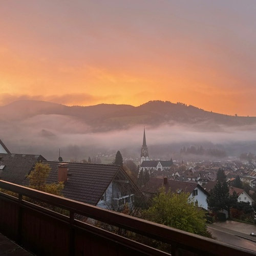 Blick vom Balkon auf den orangefärbten Abendhimmel über Schönau - 